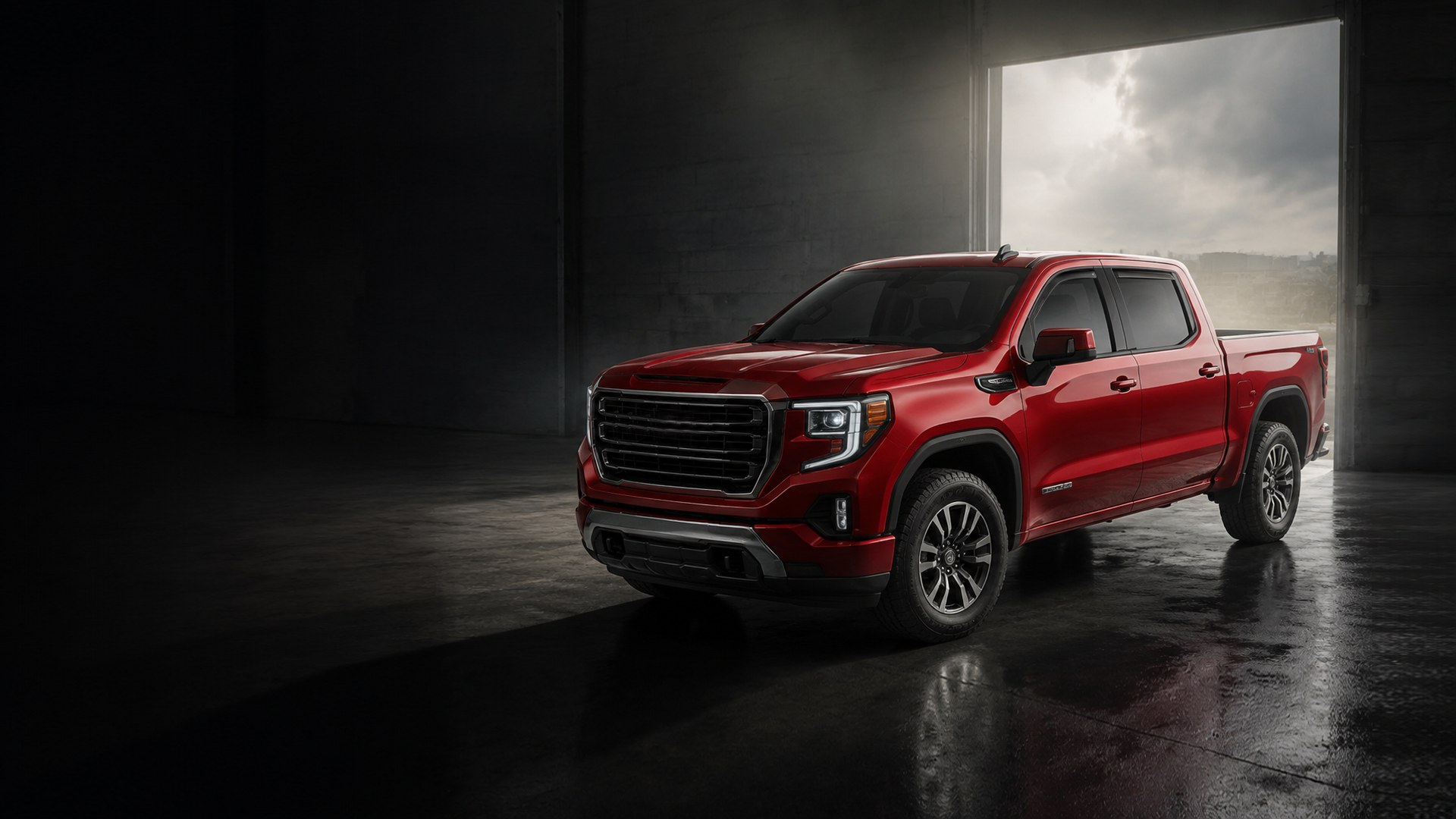 Red pickup truck fitted with Voron Glass window deflectors, parked in a dark garage